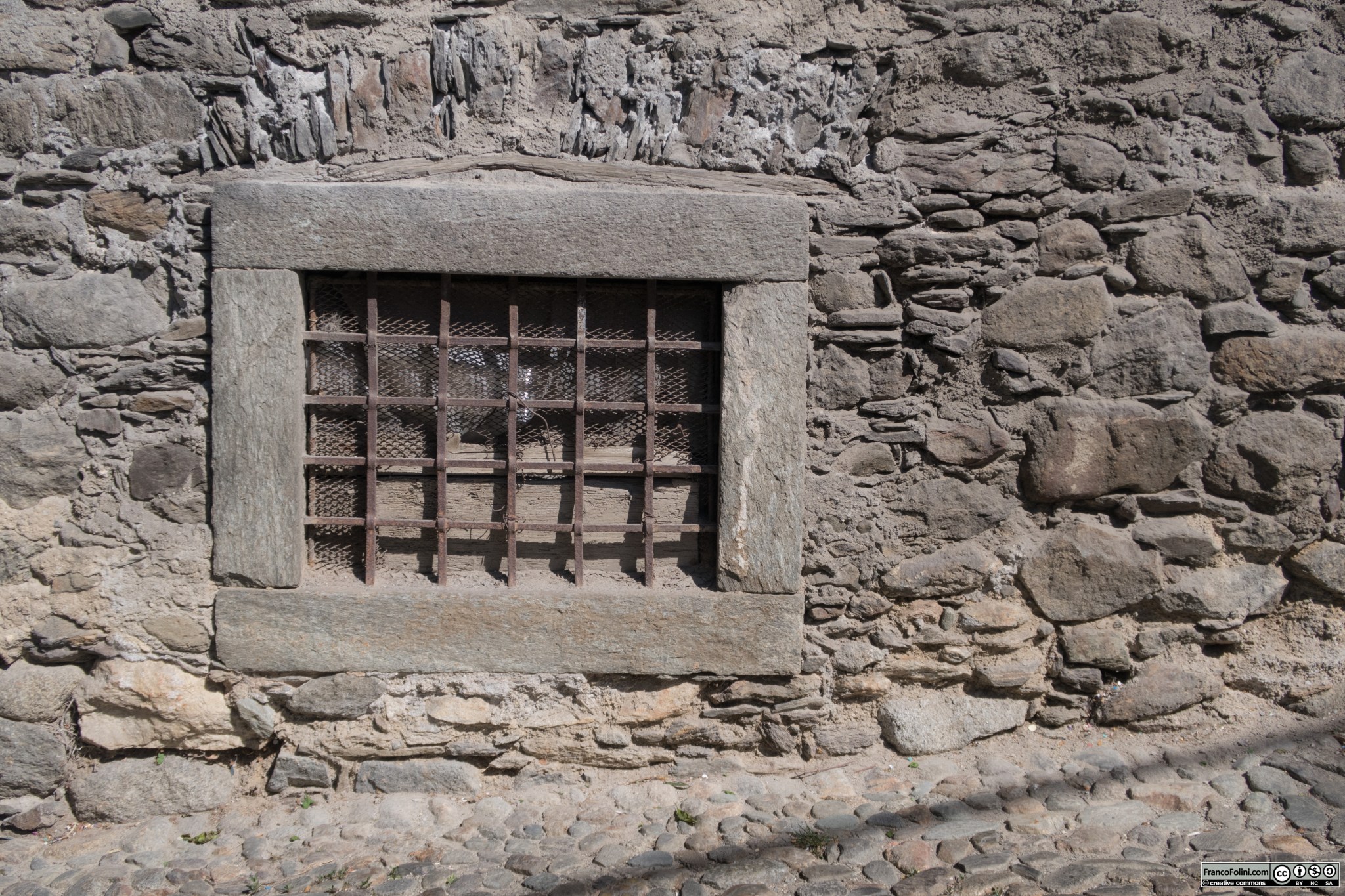 Antico finestruolo medievale con grata, Ponte in Valtellina