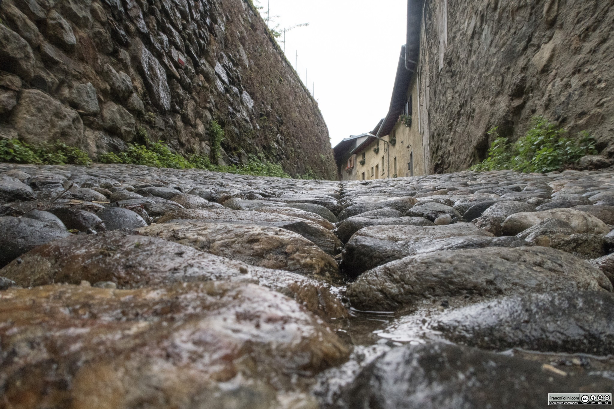 Acciottolato in via Paradiso. Come mi fa notare Norma Ghizzo, la posa del ciottolato crea una depressione in mezzo alla strada in modo che le acque meteoriche convergano verso il centro in un ruscellamento controllato. Il camminamento laterale è libero da pozzanghere e sono salvaguardati i muri delle case.