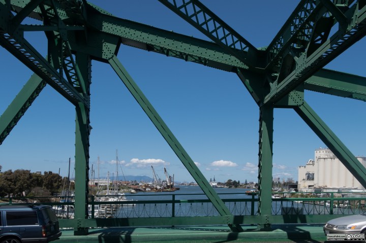 Park Street Bridge. The Park Street Bridge is a double-leaf bascule drawbridge spanning 372 feet of the Oakland Estuary in the San Francisco Bay Area. It links the cities of Oakland and Alameda. In a year, the bridge is opened approximately 1700 times and carries approximately 40,000 vehicles per work day