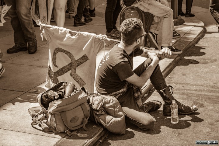 Contestatore solitario si riposa poco lontano dalla folla urlante