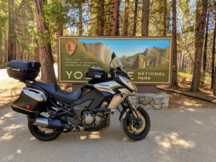 Kawasaki Versys 1000 davanti al vistoso cartellone che annuncia l'ingresso "Big Oak Flat" del parco di Yosemite National Park