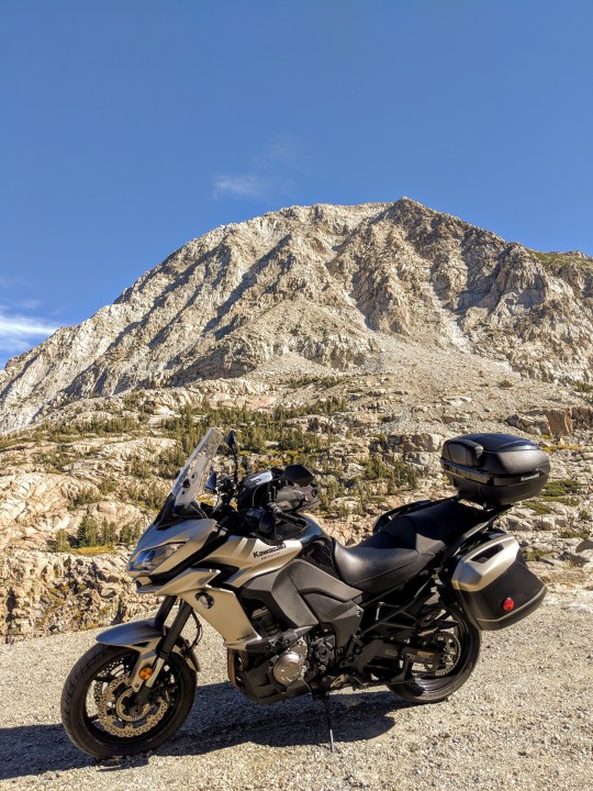 L’ultima discesa della strada del passo Tioga, California, attraversa una valle ripidissima circondata da monti di nuda roccia. Sempre la kawasaki Versys 1000 LT in primo piano.