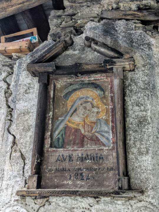 Edicola votiva. Vergine Maria col bambin Gesù. Iscrizione: “Ave Maria, Maria Angiolini F.F.P.D. 1824”.