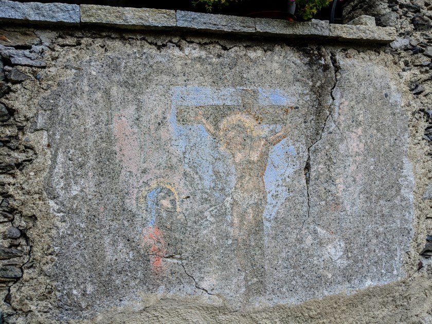 Affresco votivo scolorito dal tempo. Crocifissione. Arigna (Fontaniva), provincia di Sondrio.
